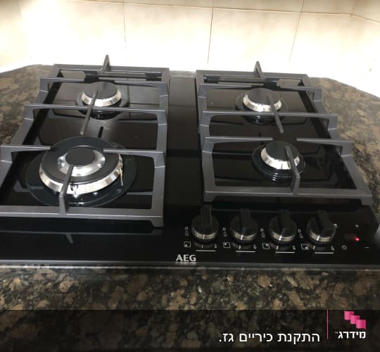 כיריים גז עם ארבעה מבערים וכפתורי שליטה